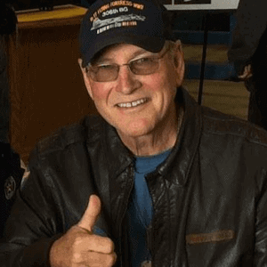Steve Snyder, author, smiling in a leather jacket and baseball cap, promoting his books on World War II history.